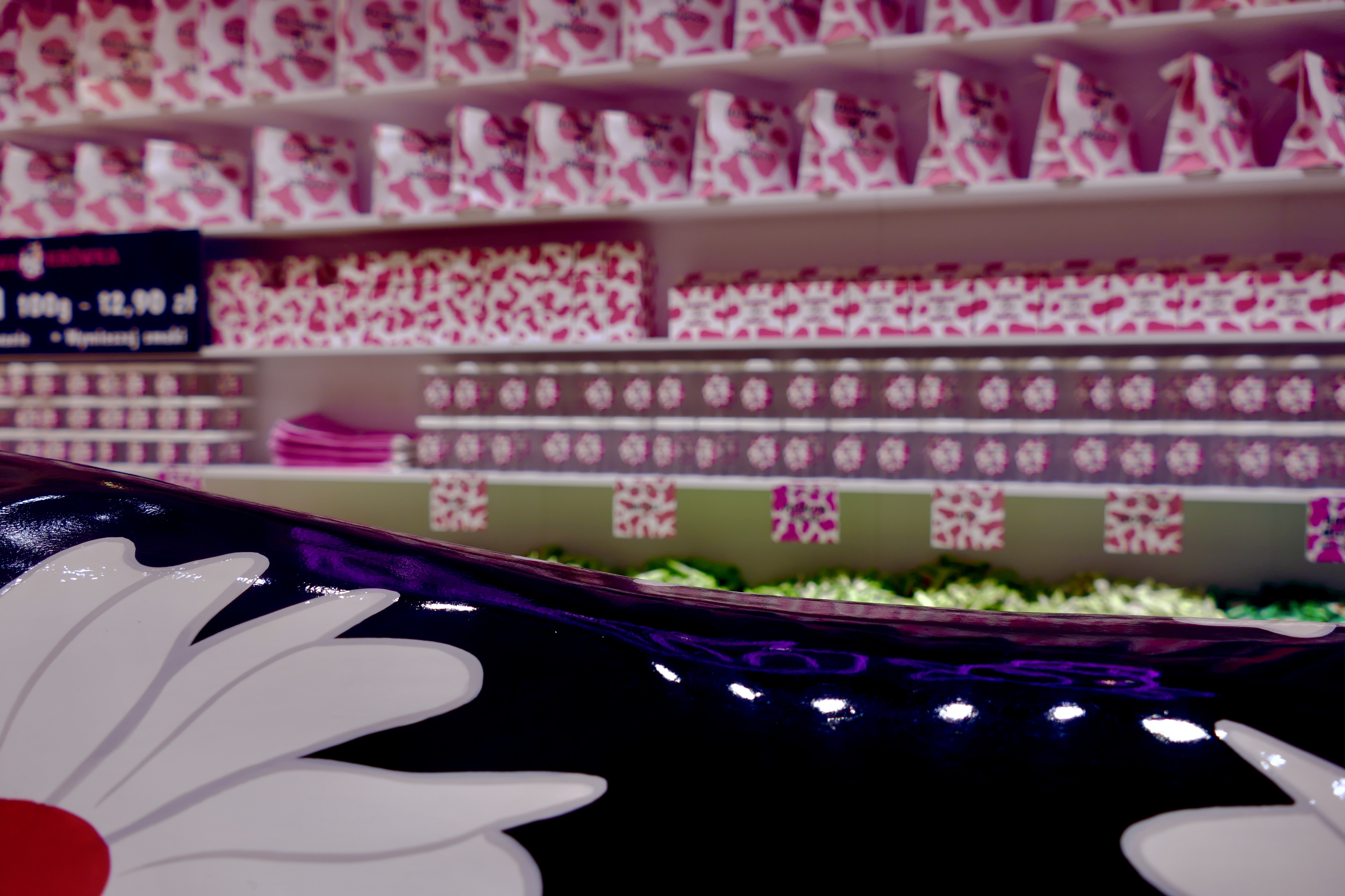 Photo of a MUUU shop in Wroclaw, in the foreground a black cow with white flowers.
